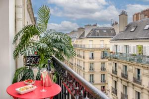 un balcón con una mesa con bebidas y un plato de comida en Avalon Hotel, en París