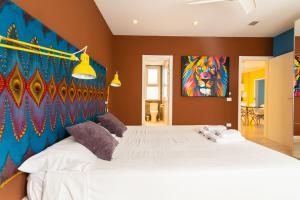 ein Schlafzimmer mit einem großen Bett mit einem Gemälde an der Wand in der Unterkunft Africa Master Suite in Las Palmas de Gran Canaria