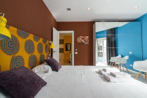 ein Schlafzimmer mit einem großen weißen Bett mit lila Kissen in der Unterkunft Africa Master Suite in Las Palmas de Gran Canaria