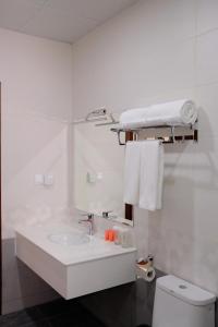 ein weißes Bad mit einem Waschbecken und einem WC in der Unterkunft Dormitory Hualing Tbilisi in Tbilisi City