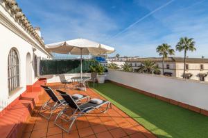 un patio con sillas y una sombrilla en el balcón en Hotel Jerez Centro en Jerez de la Frontera