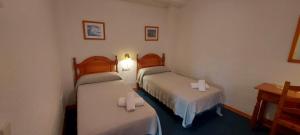 Habitación de hotel con 2 camas con sábanas blancas en Hotel Mairena, en Mairena del Alcor