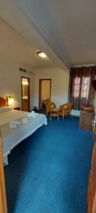 Habitación de hotel con cama y alfombra azul en Hotel Mairena, en Mairena del Alcor