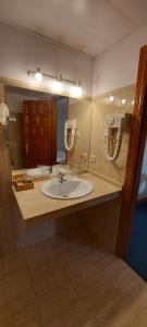 ein Badezimmer mit einem Waschbecken und einem großen Spiegel in der Unterkunft Hotel Mairena in Mairena del Alcor