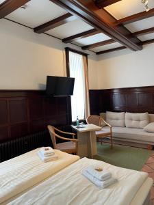 a hotel room with two beds and a couch at Hotel Brauhaus Bückeburg in Bückeburg