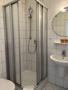 a bathroom with a shower and a toilet and a sink at Hotel Brauhaus Bückeburg in Bückeburg