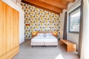 sypialnia z łóżkiem i oknem w obiekcie Hotel Al Castello w mieście Torri del Benaco