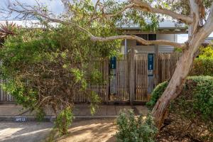 a house with a wooden gate and a tree at Oceanic Sorrento Apartment 11 in Sorrento