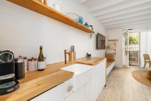 a kitchen with white cabinets and a wooden counter top at Oceanic Sorrento Apartment 11 in Sorrento +13 photos