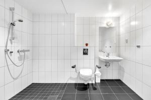 La salle de bains est pourvue de toilettes et d'un lavabo. dans l'établissement Forenom Aparthotel Oslo, à Oslo