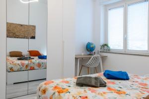 a bedroom with two beds and a table and a chair at Casa Mila in Milan