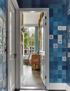 einen Flur mit blauen Fliesen an den Wänden in der Unterkunft Pulitzer Amsterdam in Amsterdam
