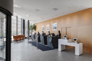 een groep mensen aan een tafel in een lobby bij Clarion Hotel Sign in Stockholm