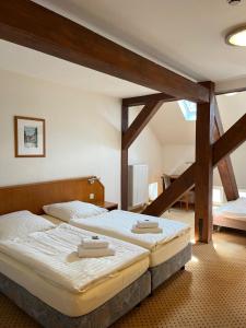 two twin beds in a room with wooden beams at Hotel Brauhaus Bückeburg in Bückeburg