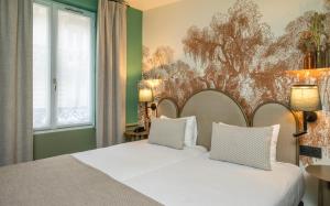 1 dormitorio con 1 cama blanca grande y 2 almohadas en Avalon Hotel, en París