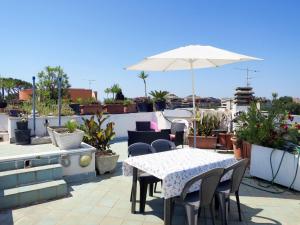Un patio con una mesa y sillas y una sombrilla. en Holiday Home Casa Le Terrazze by Interhome, en Nettuno