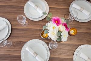 a table with white plates and a vase of flowers at Covent Garden 2BR - Urban Chic Apartment in London +23 photos
