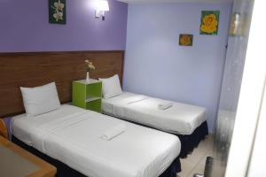 2 camas en una habitación con paredes moradas en Boutique Hote123, en Kuala Lumpur