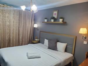 1 dormitorio con 1 cama grande con sábanas blancas en Boutique Hote123, en Kuala Lumpur