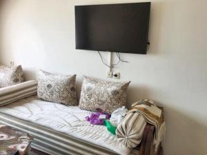 Elle comprend un canapé blanc avec des oreillers et une télévision murale. dans l'établissement One bedroom apartement at Rabat, à Rabat