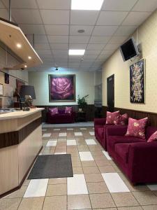 a lobby with two purple couches in a room at Via Baltica in Sargėnai