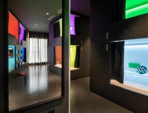 una camera con corridoio con pareti colorate e specchio di AMISTAT City Hostel Barcelona a Barcellona