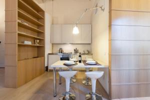 una cucina con tavolo e due sgabelli di Vigna Nuova Suites a Firenze