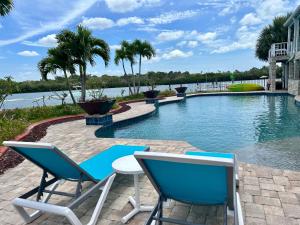 a swimming pool with two chairs and a table at Guest suite - Waterfront -Pool & Hot tub- Walk to Beach in Clearwater Beach
