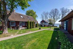 a house with a grass yard next to a building at Preila Kristina -1 in Neringa