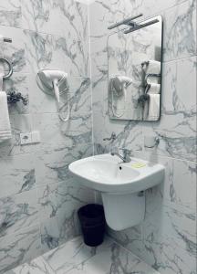 a white bathroom with a sink and a mirror at Via Baltica in Sargėnai