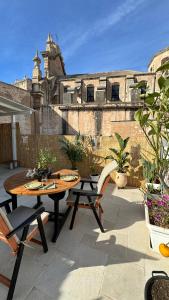 un patio avec une table et des chaises et un bâtiment dans l'établissement DIMORA MOLINI, à Monopoli