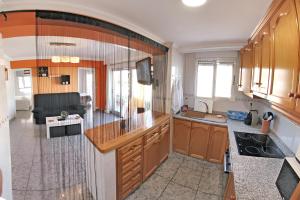 cocina con armarios de madera y sala de estar. en 3 bedrooms apartement with city view balcony and wifi at Villena, en Villena