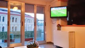 sala de estar con TV y ventana grande en 3 bedrooms apartement with city view balcony and wifi at Villena, en Villena