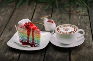 um pedaço de bolo e uma chávena de café em Denchaicity Resort เด่นชัยซิตี้ รีสอร์ท em Phrae