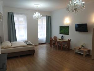 a living room with a bed and a dining room at Apartments Paderewski in Karlovy Vary