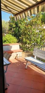 a bench sitting on a patio under a pergola at One bedroom apartement at Lacona 100 m away from the beach with enclosed garden in Lacona
