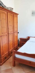 a bedroom with a bed and wooden cabinets at One bedroom apartement at Lacona 100 m away from the beach with enclosed garden in Lacona