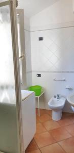 a white bathroom with a sink and a toilet at One bedroom apartement at Lacona 100 m away from the beach with enclosed garden in Lacona