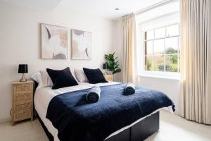 1 dormitorio con 1 cama grande con manta azul en Stunning 2 Bedroom Apartment in Converted Chapel en Bath