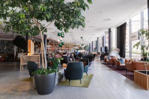 un hall d'un magasin avec des chaises et des plantes dans l'établissement Clarion Hotel Sign, à Stockholm