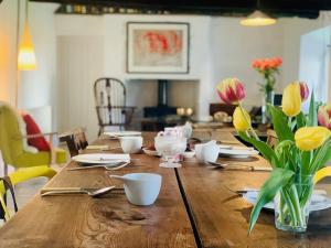 un tavolo in legno con fiori in una sala da pranzo di The Croft Place of Architectual Interest a Lochearnhead