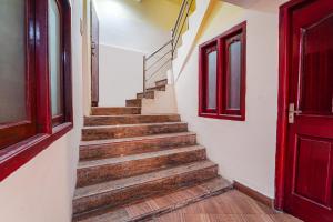 a staircase in a building with a red door at FabHotel Roshan Residency Naidupuram in Kodaikānāl