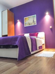 een slaapkamer met een bed met een paarse muur bij One bedroom apartement with shared pool enclosed garden and wifi at Rakovica in Rakovica