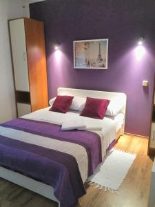 een slaapkamer met een groot bed met paarse muren bij One bedroom apartement with shared pool enclosed garden and wifi at Rakovica in Rakovica