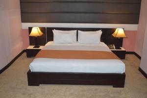 a bedroom with a large bed with two lamps at Fort Continental Hotel in Peshawar +32 photos
