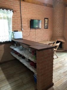 eine Küche mit einer gemauerten Theke mit Limonadenflaschen in der Unterkunft Chalé mirante da Serra rua E nova ibitipoca Lima Duarte MG in Ibitipoca