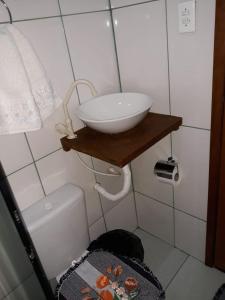 ein Badezimmer mit einem Waschbecken auf einem Regal neben einer Toilette in der Unterkunft Chalé mirante da Serra rua E nova ibitipoca Lima Duarte MG in Ibitipoca + 7 Fotos