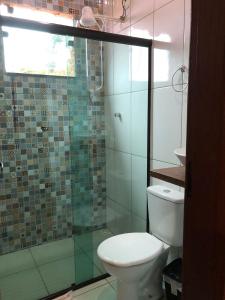 ein Badezimmer mit Toilette und Glasdusche in der Unterkunft Chalé mirante da Serra rua E nova ibitipoca Lima Duarte MG in Ibitipoca