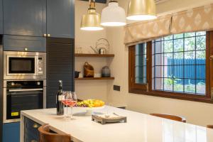 a kitchen with a table with a bowl of fruit and wine glasses at Hostie Vaikuntha - 3BHK Mountain Villa, Dehradoon in Dehradun