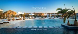 a swimming pool with chairs and umbrellas at a resort at Marmarica Boutique Cabanas - Ras El Hekma - North Coast Top Rated Luxury Stay in Marsa Matruh